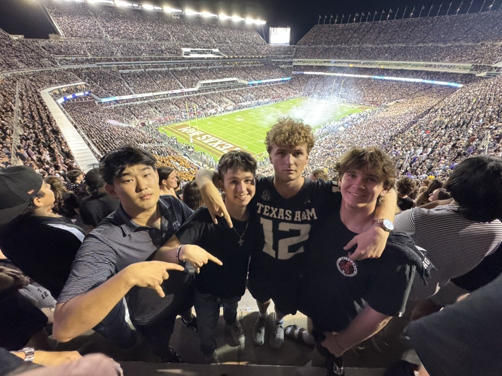 Jake at a Texas A&M football game with stadium in the background.